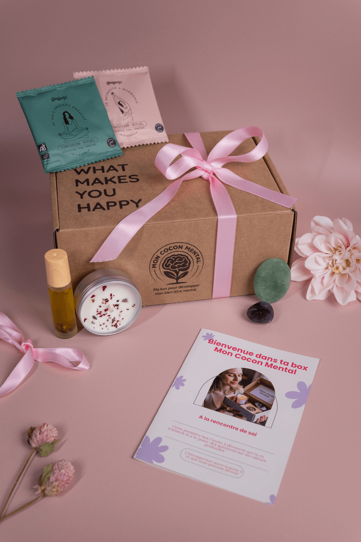 Carte cadeau présentée dans une box de bien-être avec un ruban, des produits de soin et une lettre d'accueil.